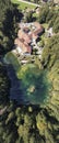 Top down aerial portrait panorama image of hotel resort on beautiful clear blue lake surrounded by trees Royalty Free Stock Photo