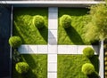 Top down aerial view of an austere minimalist garden with a crisscrossed light flagstone path on a trimmed lawn, made with Royalty Free Stock Photo