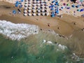 Top down aerial view of a busy beach with sun umbrellas (Nea Chora, Chania, Crete