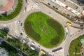 Top down aerial view of busy street roundabout intersection with moving cars traffic