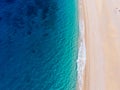 Top-down aerial view of a white sandy beach on the shores of a beautiful turquoise sea. Royalty Free Stock Photo