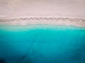 Top-down aerial view of a white sandy beach on the shores of a beautiful turquoise sea. Royalty Free Stock Photo