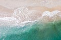 Top-down aerial view of a clean white sandy beach on the shores of a beautiful turquoise sea Royalty Free Stock Photo