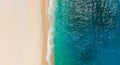 Top-down aerial view of a clean white sandy beach on the shores of a beautiful turquoise sea Royalty Free Stock Photo