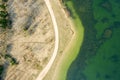 Top down aerial view of dirt road on lake shore. spring sunny landscape Royalty Free Stock Photo