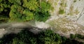 Top down aerial view of the folowing dron along the wilderness, the rivers along the cliff