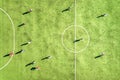 Top down aerial view of green football sports field and players playing football. Drone taken image of small unrecognizable Royalty Free Stock Photo