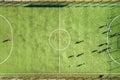 Top down aerial view of green football sports field and players playing football. Drone taken image of small unrecognizable Royalty Free Stock Photo