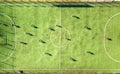 Top down aerial view of green football sports field and players playing football. Drone taken image of small unrecognizable Royalty Free Stock Photo