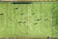 Top down aerial view of green football sports field and players playing football. Drone taken image of small unrecognizable Royalty Free Stock Photo