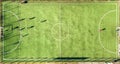 Top down aerial view of green football sports field and players playing football. Drone taken image of small unrecognizable Royalty Free Stock Photo