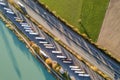 Top down aerial view of highway interstate road with fast moving traffic and parking lot with parked lorry trucks