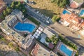 Top down aerial view of hotels roofs, streets with parked cars and swimming pools with blue water in resort city near the sea Royalty Free Stock Photo