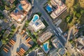 Top down aerial view of hotels roofs, streets with parked cars and swimming pools with blue water in resort city near the sea Royalty Free Stock Photo