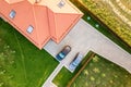 Top down aerial view of a private house with red tiled roof and spacious yard with parked two new cars Royalty Free Stock Photo