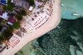 Top down aerial view of tables and seats on a tropical sandy beach during sunset on a small island