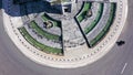 Top down aerial view of a traffic roundabout on a main road in an urban area