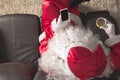 Top-down angle of Santa Claus sitting in sofa at home Holding ce Royalty Free Stock Photo