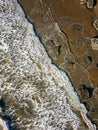 Top down areial view of waves breaking against rocks and a sandy beach Royalty Free Stock Photo