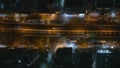 Top down ascending shot of vehicles driving on multilevel and multilane thoroughfare in night city. Transport