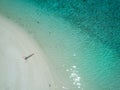 TOP DOWN: Carefree woman lying on the sandy beach with her arms outstretched. Royalty Free Stock Photo