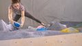 TOP DOWN: Caucasian woman climbs towards the top of an indoor bouldering wall. Royalty Free Stock Photo