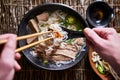 Top down composition of eating vietnamese pho with chopsticks and spoon, has dab of sriracha for flavor Royalty Free Stock Photo