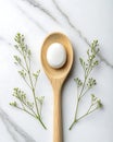 White Egg in Wooden Spoon with Greenery on Marble Surface Royalty Free Stock Photo