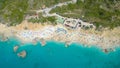 TOP DOWN: Flying above crowded white sand beach full of colorful umbrellas. Royalty Free Stock Photo