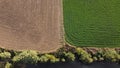 Separation and contrast between a harvested field and a plowed field in rural agricultural farmland,