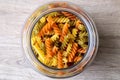 A top down portrait of a glass pot, jar or bowl full of spirelli in three different colors. The uncooked tricolore italian pasta Royalty Free Stock Photo