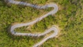 TOP DOWN: Scenic shot of a car driving along empty road winding through a forest