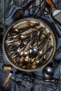 A top down view of an abstract arrangement of antique utensils and cutlery in a metal tray against a dark background. Royalty Free Stock Photo