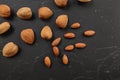 Top down view, almonds, both whole and cracked, on dark marble board