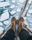 A top-down view of an Arctic explorer\'s feet on the deck of their old sailing ship. Generative AI. Royalty Free Stock Photo
