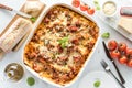 A top down view of a baked lasagna ready for serving surrounded by Italian ingredients. Royalty Free Stock Photo