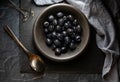 Top down view of a black bowl filled with black olives against a dark background. Royalty Free Stock Photo