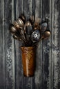 A top down view of a bronze metal vase filled with antique cutlery and utensils. Royalty Free Stock Photo