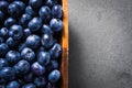 Top Down View Of A Bunch Of Blueberries In A Wooden Bowl, Standing On Slate Stone