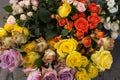 A top down view of bunches of multi-coloured roses for sale at a local market