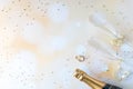 A top down view of champagne flutes, bottle and wedding bands against a bokeh background and glitter all around. Royalty Free Stock Photo