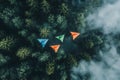 Top down view of colorful paper airplanes flying over a forest Royalty Free Stock Photo