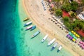Top down view of colorful sunshades and tourist boats on a tropical beach Royalty Free Stock Photo