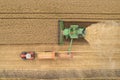 Top down view of combine harvester on wheat field and unloading to tractor trailer Royalty Free Stock Photo