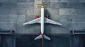 Top down view on commercial airplane docking in terminal in the parking lot of the airport apron, waiting for services Royalty Free Stock Photo