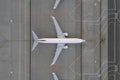 Top down view on comercial airplane in the parking lot of the airport apron, waiting for services maintenance, refilling fuel