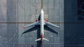 Top down view on commercial airplane docking in terminal in the parking lot of the airport apron, waiting for services Royalty Free Stock Photo