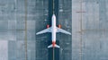 Top down view on commercial airplane docking in terminal in the parking lot of the airport apron, waiting for services Royalty Free Stock Photo