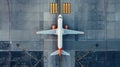 Top down view on commercial airplane docking in terminal in the parking lot of the airport apron, waiting for services Royalty Free Stock Photo