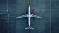 Top down view on commercial airplane docking in terminal in the parking lot of the airport apron, waiting for services Royalty Free Stock Photo